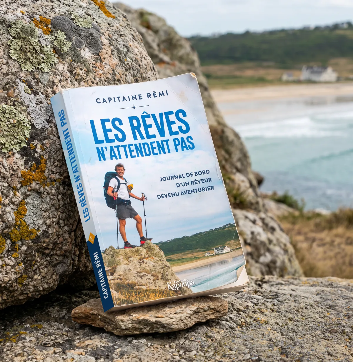 Le livre Les Rêves n'attendent pas de Capitaine Rémi, posé sur les rochers en Bretagne
